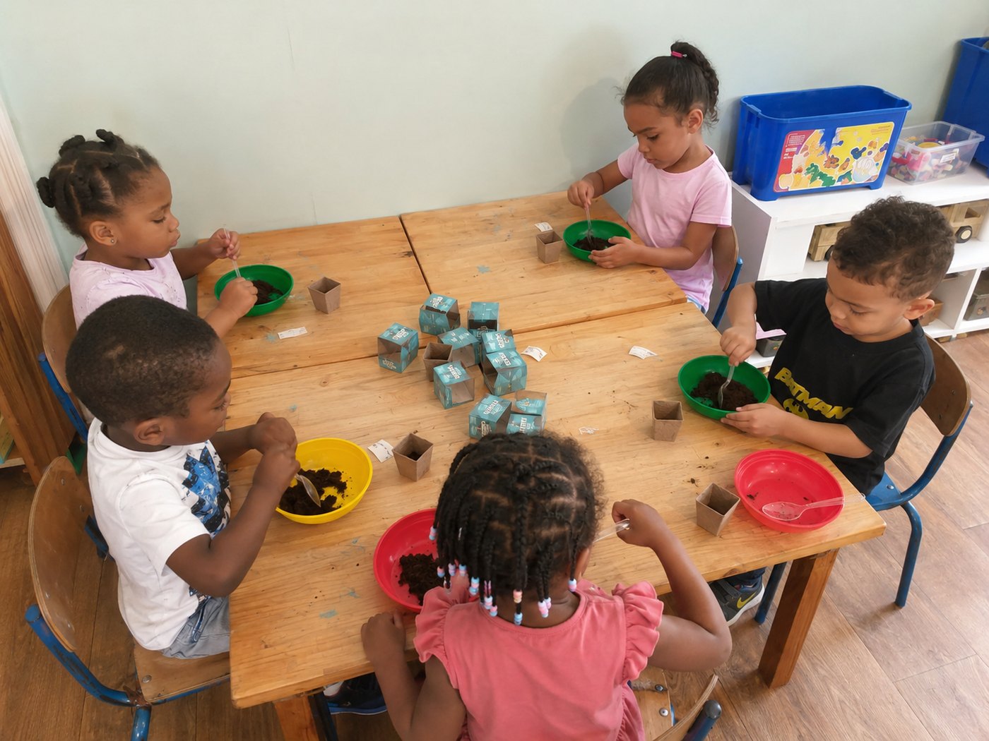 The whole table filling their own little pots with soil and seeds