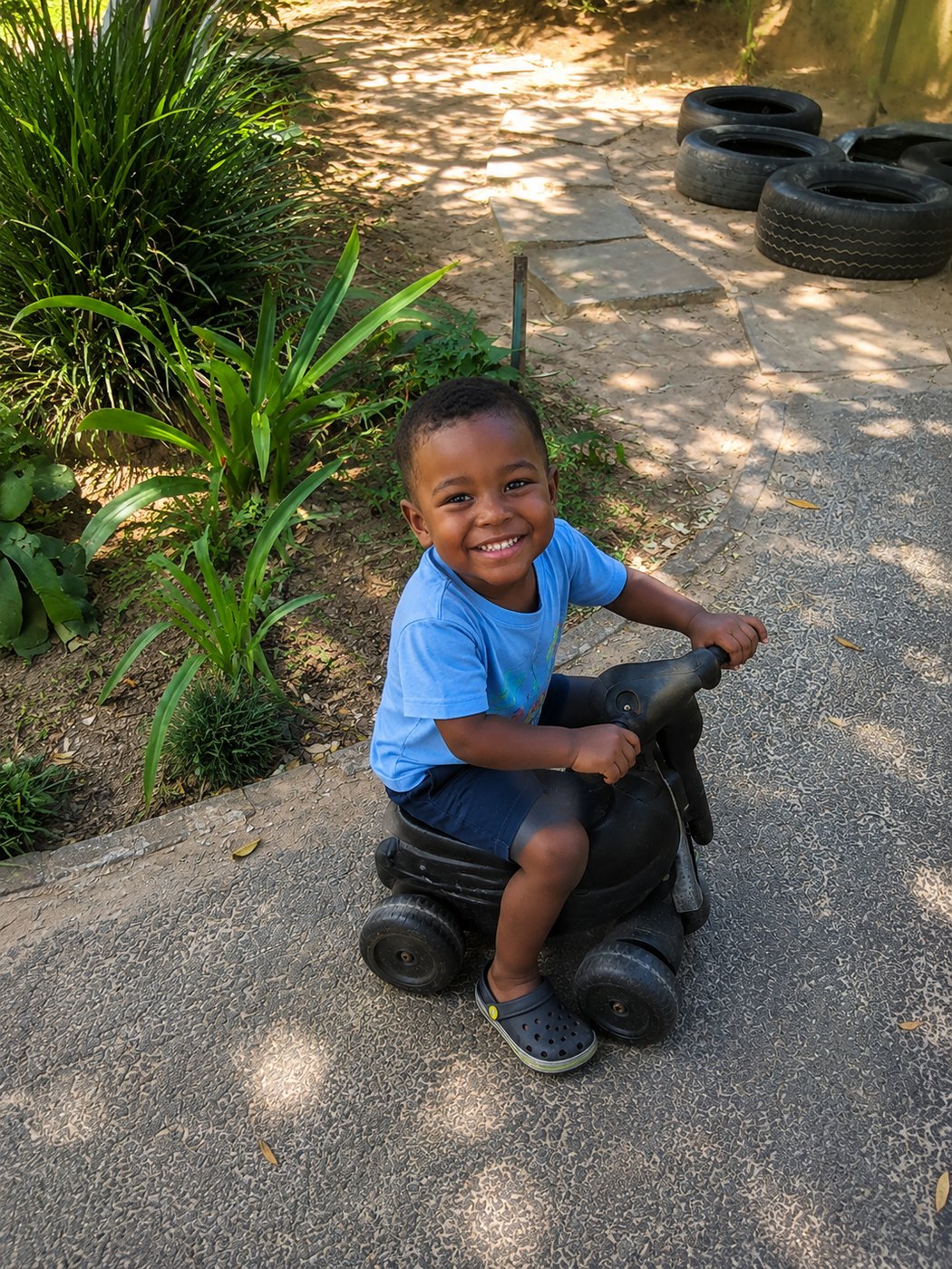 All smiles on the scooter, cruising down the path